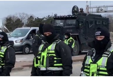 *BREAKING* WINDSOR POLICE MOVE IN – Begin Removing Protesters Blocking Ambassador Bridge to US — Snipers on the Roof – City Buses Arrive for Arrests –